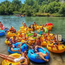 a group of people in inner tubes on a river