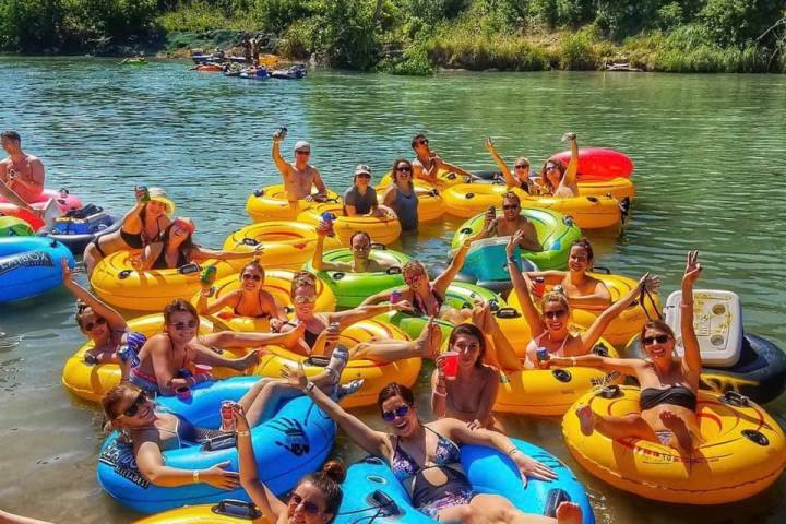 a group of people in inner tubes on a river