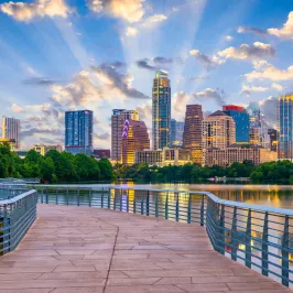 a bridge over a body of water with a city in the background