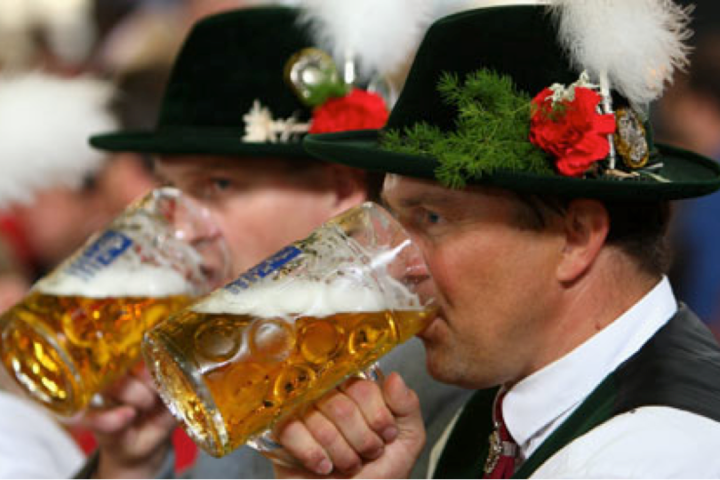 two men drinking beer out of steins