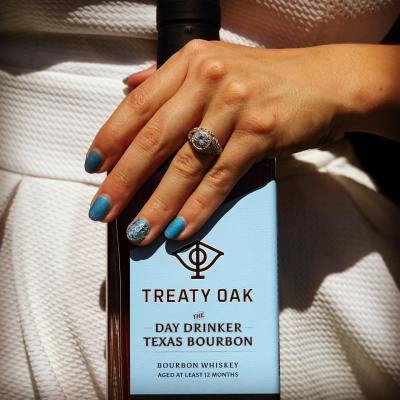 a woman holding a bottle of bourbon