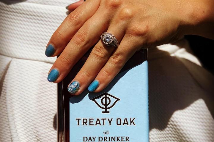 a woman holding a bottle of bourbon