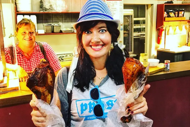 a woman holding two turkey legs