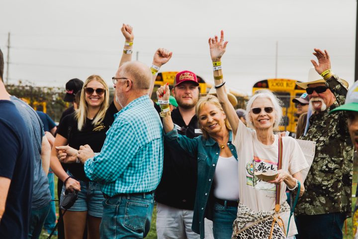 a group of people standing in front of a crowd posing for the camera